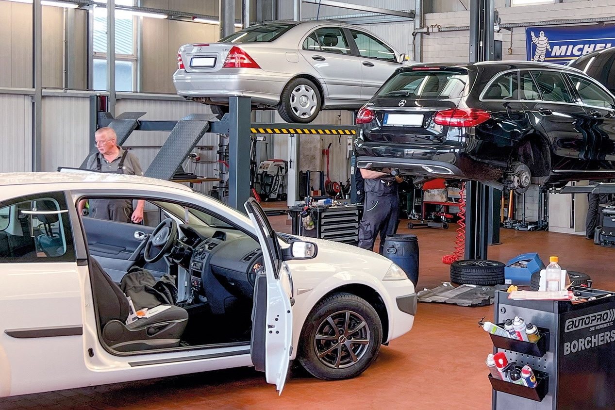 Mitarbeiter der BORCHERS GMBH an einem Fahrzeug in der Werkstatt